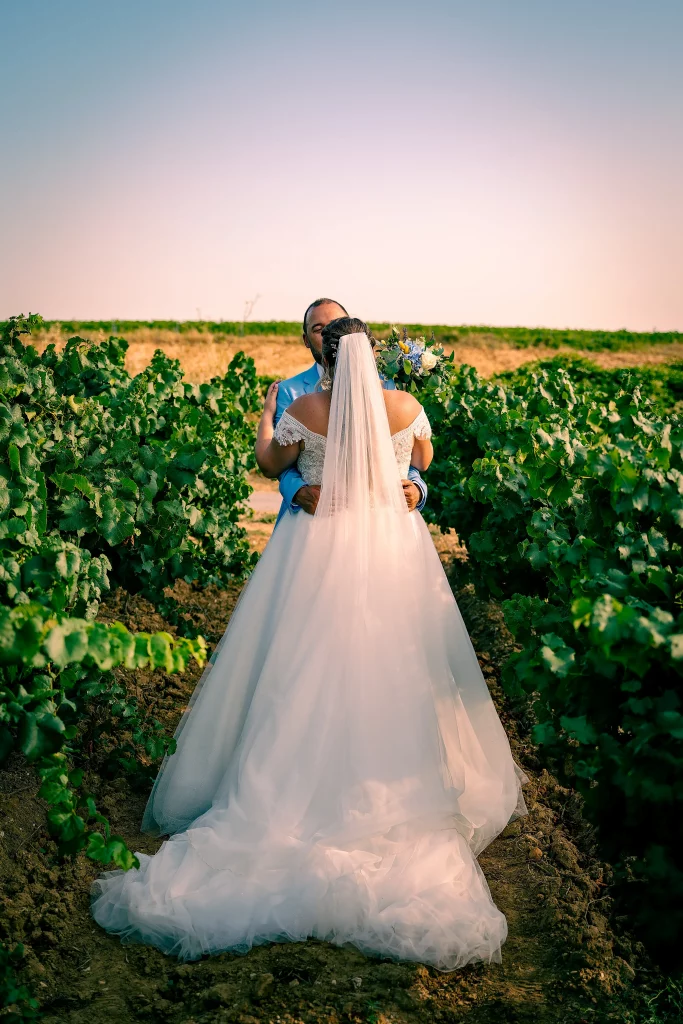 La mariée marche de dos dans la lumière de fin de journée