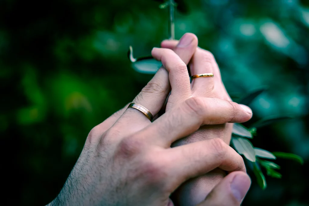 Les mains du couple et leurs alliances