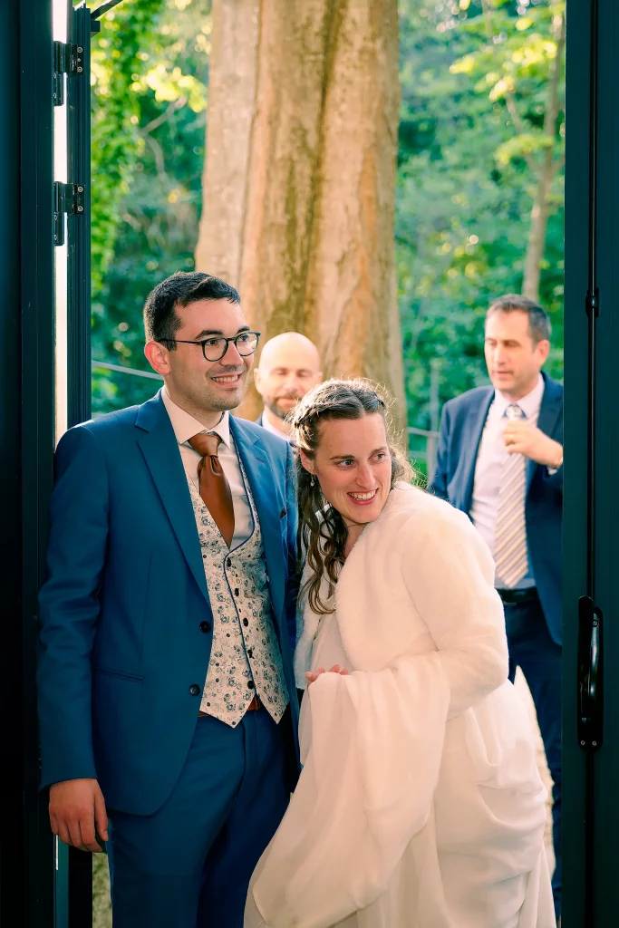 Le couple accompagné de ses proches devant une façade en pierre