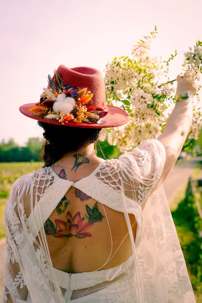 La mariée photographiée de dos dans la lumière du jardin