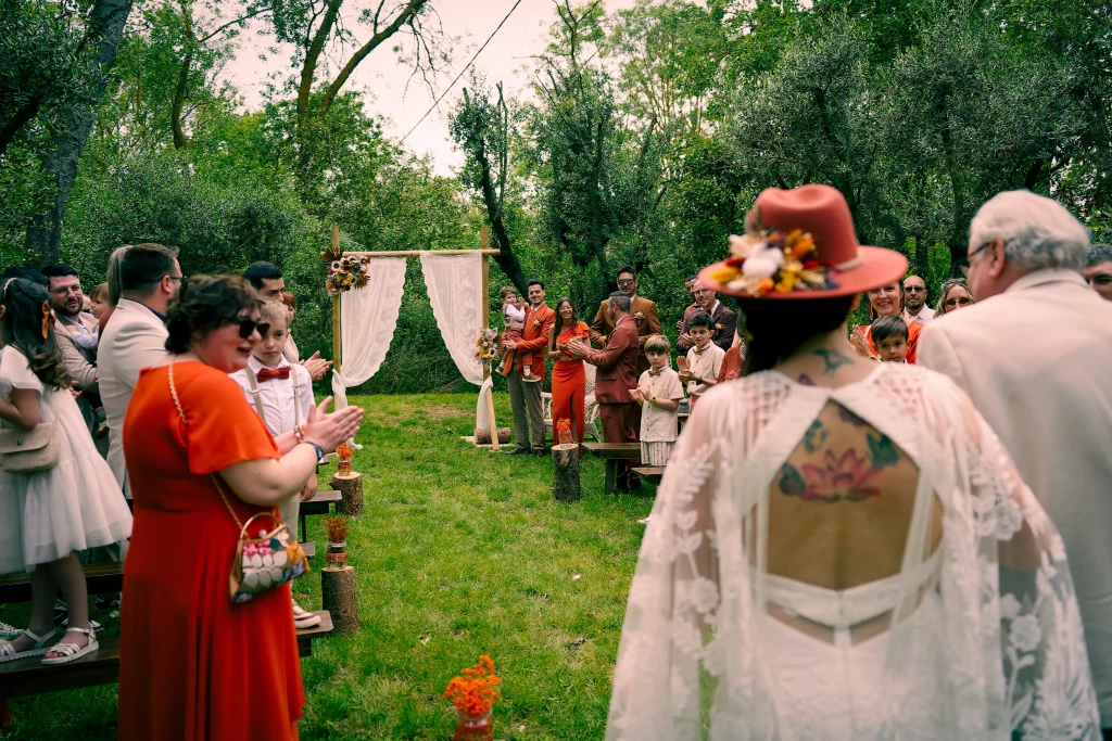 La mariée vue de dos parmi les invités en extérieur
