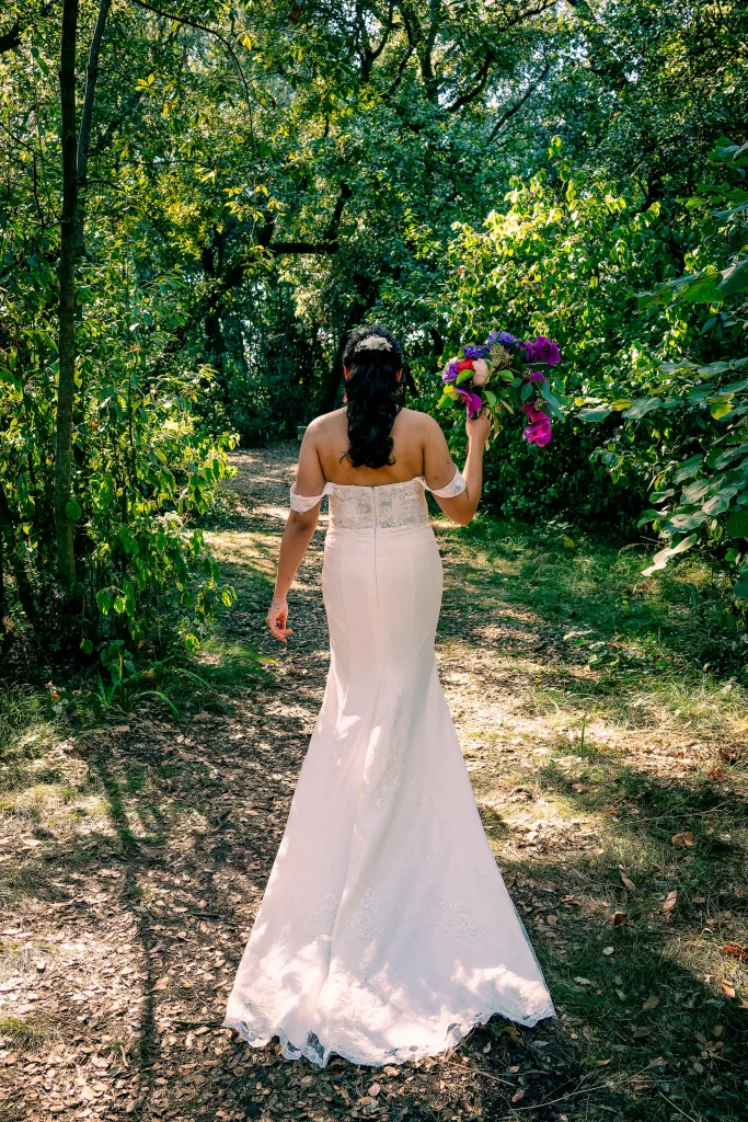 La mariée marche dans le parc arboré