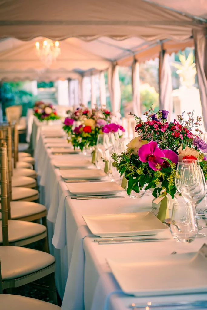 Table de réception et bouquets de fleurs sous la tente