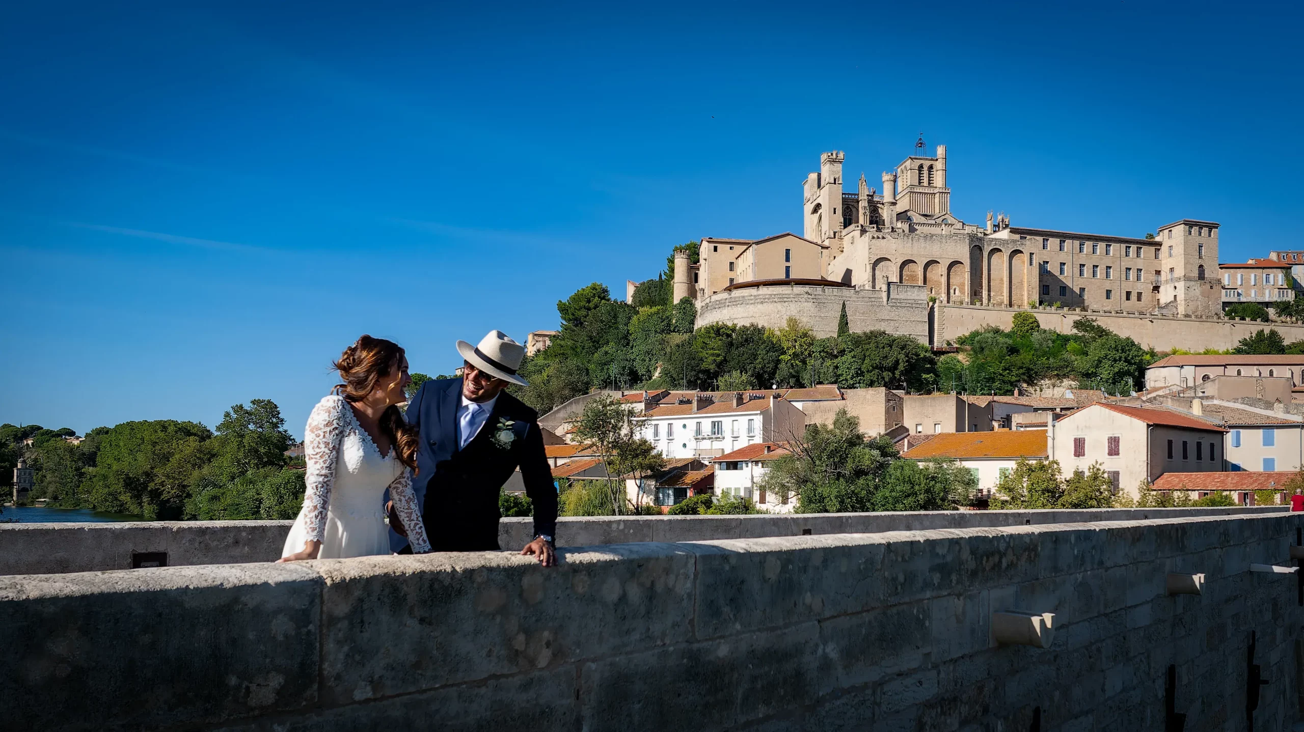Couple sur le Pont Vieux avec la cathédrale Saint-Nazaire en arrière-plan à Béziers
